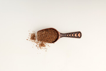 Milk Thistle Powder in metal scoop, top view. Milk Thistle Oil cake or Silybum marianum extract. Herbal superfood for aiding liver function. Strong antioxidant