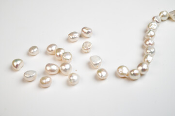 Natural freshwater round pearl beads on white background. Top view