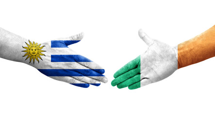 Handshake between Ireland and Uruguay flags painted on hands, isolated transparent image.