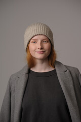 young girl model in beige hipster hat and coat isolated on light background. Product photo mockup for fashion brands and marketplaces, woolen cap, turkish textiles.