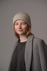 young girl model in beige hipster hat and coat isolated on light background. Product photo mockup for fashion brands and marketplaces, woolen cap, turkish textiles.