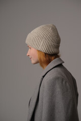 young girl model in beige hipster hat and coat isolated on light background. Product photo mockup for fashion brands and marketplaces, woolen cap, turkish textiles.
