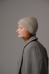 young girl model in beige hipster hat and coat isolated on light background. Product photo mockup for fashion brands and marketplaces, woolen cap, turkish textiles.