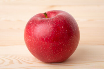Red fresh apple on wooden background. Close up shot of an apple on the table