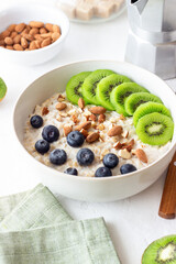Oatmeal with kiwi, blueberries, almonds and honey. Healthy food. Vegetarian food. Breakfast.