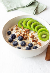 Oatmeal with kiwi, blueberries, almonds and honey. Healthy food. Vegetarian food. Breakfast.