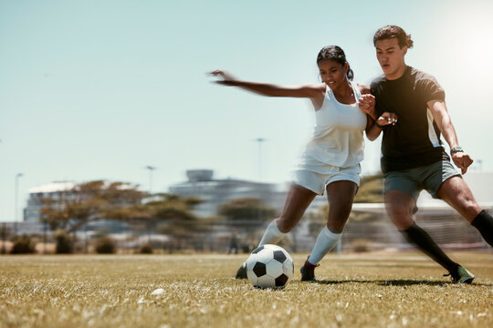 Sport, friends and soccer with man and woman playing on a soccer field, competitive training for sports goal. Fitness, couple and energy with interracial guy and lady having fun with outdoor football