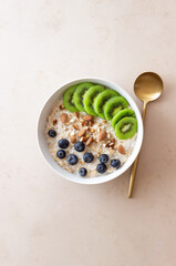 Oatmeal with kiwi, blueberries, almonds and honey. Healthy food. Vegetarian food. Breakfast.