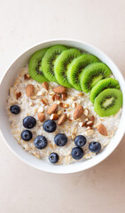 Oatmeal with kiwi, blueberries, almonds and honey. Healthy food. Vegetarian food. Breakfast.