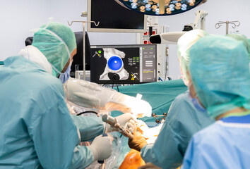Team of doctor perform total hip arthroplasty replacement surgery in osteoarthritis patient inside...