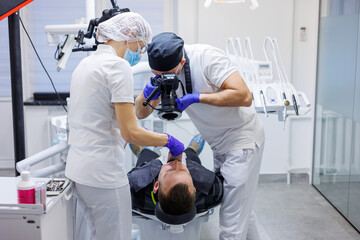 A young dentist takes a picture of the patient's teeth. The assistant helps the doctor. Dental...
