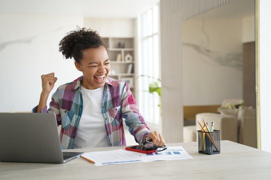 Excited mixed race teen girl student got good news email on laptop celebrates personal achievement