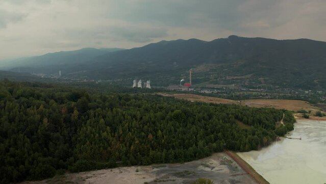 Aerial view of Forest and mountain landscape viewed from Transvalcan, Hunedoara. Caprisoara coal mine waste lake, near Vulcan Town. Cloudy summer day, in the Romanian mountains. Environmental waste. 