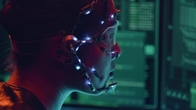Side view of an Asian girl with futuristic headset and microphone programming using multiple computer screen. Cyperpunk style. Sci-fi background.