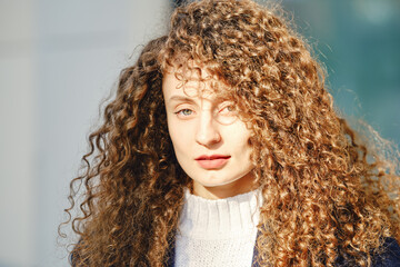 Portrait of a woman with brown curly hair