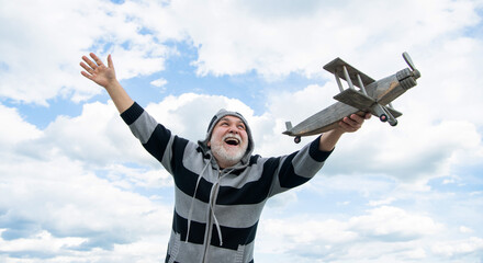 happy senior man high on sky background. senior man at retirement. senior retired man with toy plane