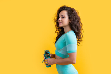 smiling fitness sportswoman with sport water bottle in studio. fitness sportswoman