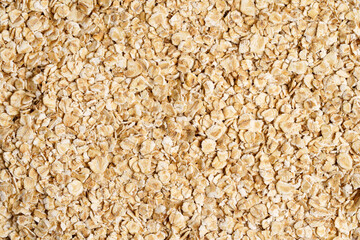 Rolled oat, oat flakes background or texture. Close up, directly above.