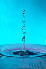 Close-up water drops falling and impacting a body of water.