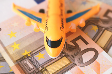 Airplane on the background of cash euros. The cost of the flight, the price of plane tickets....