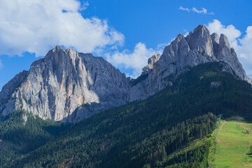 Obraz premium The landscape and the peaks of the Dolomites of the Val di Fassa, one of the most famous and touristic valleys of Trentino, near the town of Canazei, Italy - August 2022.