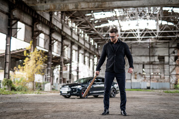 Handsome confident man in black cloth near the car. Attractive young lifestyle cool male in casual cloth.