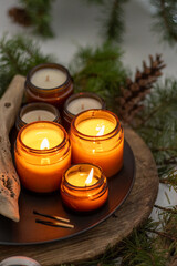 Soy candles burn in glass jars. Comfort at home. Candle in a brown jar. Scent and light. Scented handmade candle. Aroma therapy. Christmas tree and winter mood. Cozy decor. Festive decoration