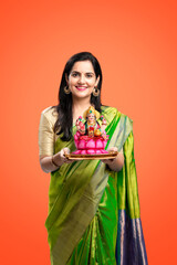 Indian young and beautiful woman in Saree holding God Lakshmi on diwali festival