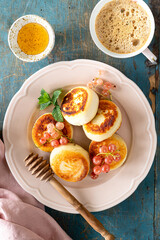 Cottage cheese pancakes or cheesecakes served with honey, top view. Ukrainian, Russian cuisine. Blue background