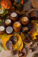 Soy candles burn in glass jars. Tree leaves. Comfort at home. Candle in a brown jar. Scent and light. Scented handmade candle. Aroma therapy. Autumn mood. Cozy home decor in fall. Festive decoration.