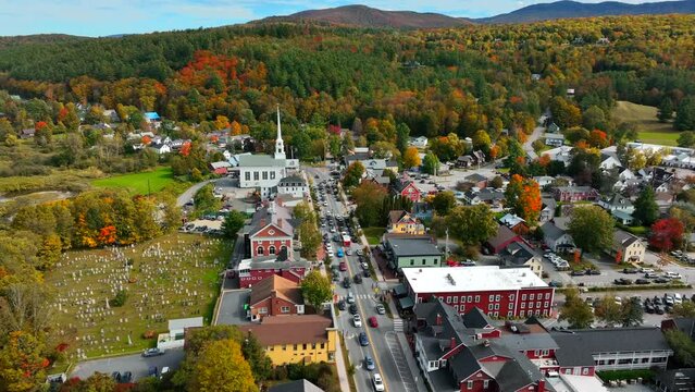 Stowe Vermont in autumn splendor. Colorful fall foliage in New England. Aerial establishing shot of ski resort town.