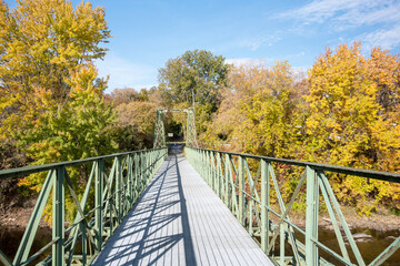 Fototapeta na wymiar Pedestrian Bridge in Autumn over the Ausable River