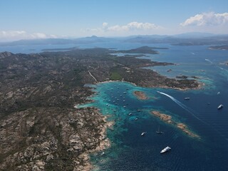 Aerial view of La Maddalena Island, Isola Giardinelli with the drone view of Caprera Island in Sardegna, Italy. Birds eye view of crystalline and turquoise water in north Sardinia, luxury yacht, boat.