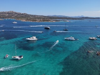 Obraz premium Aerial view of La Maddalena Island, Isola Giardinelli with the drone view of Caprera Island in Sardegna, Italy. Birds eye view of crystalline and turquoise water in north Sardinia, luxury yacht, boat.