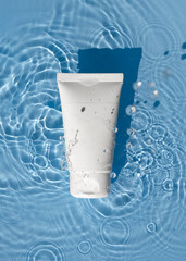 A white tube of cream lies in the water. Cream mockup