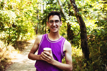 Funny young man drinking coffee in the street.