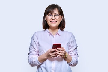 Business woman with smartphone in hands, on white background