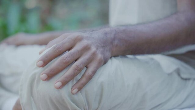 Indian yoga instructor in meditation pose as he begins a yoga session