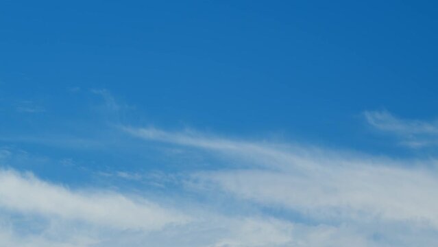 Beautiful cirrus uncinus clouds in blue sky. Clear weather, sunny day. Beautiful white cirrus clouds. Time lapse.