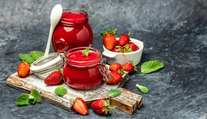 Strawberry jam in the glass jar, Homemade strawberry marmelade and fruits on a dark background. top view. place for text