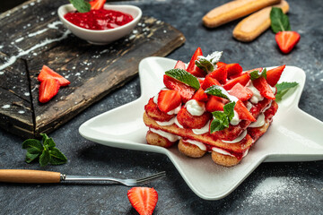 Tiramisu. Homemade tiramisu cake with fresh strawberry, mascarpone and mint. Tiramisu portion on plate on dark background. Delicious no bake tiramisu - Powered by Adobe