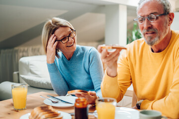 Senior couple eating breakfast at home and spending morning together