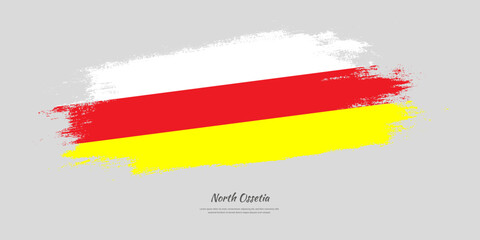 Happy Independence Day of North Ossetia. National flag on artistic stain brush stroke background.