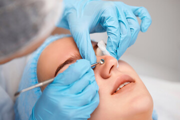 woman during a mechanical face cleansing procedure