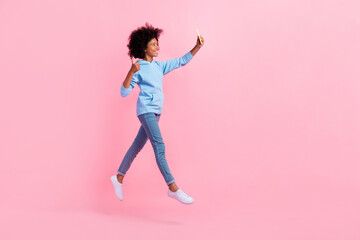 Full body profile photo of small girl jump take selfie demonstrate thumb up isolated on pink color background