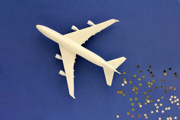Fototapeta na wymiar a plane with sequins on a blue background. the concept of travel for the New Year holidays
