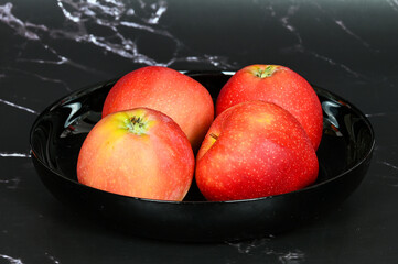 Red apples in a black plate 
