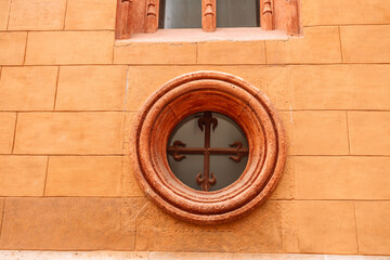 Old antique round window in an dirty wall of the monastery. Valencia, Spain in Europe.