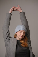 young girl model in light blue cap and gray coat isolated on grey background. Product photo mockup for fashion brands and marketplaces.