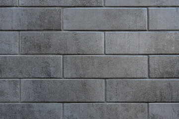 Gray brick wall background close up. Monochrome bricklaying surface backdrop